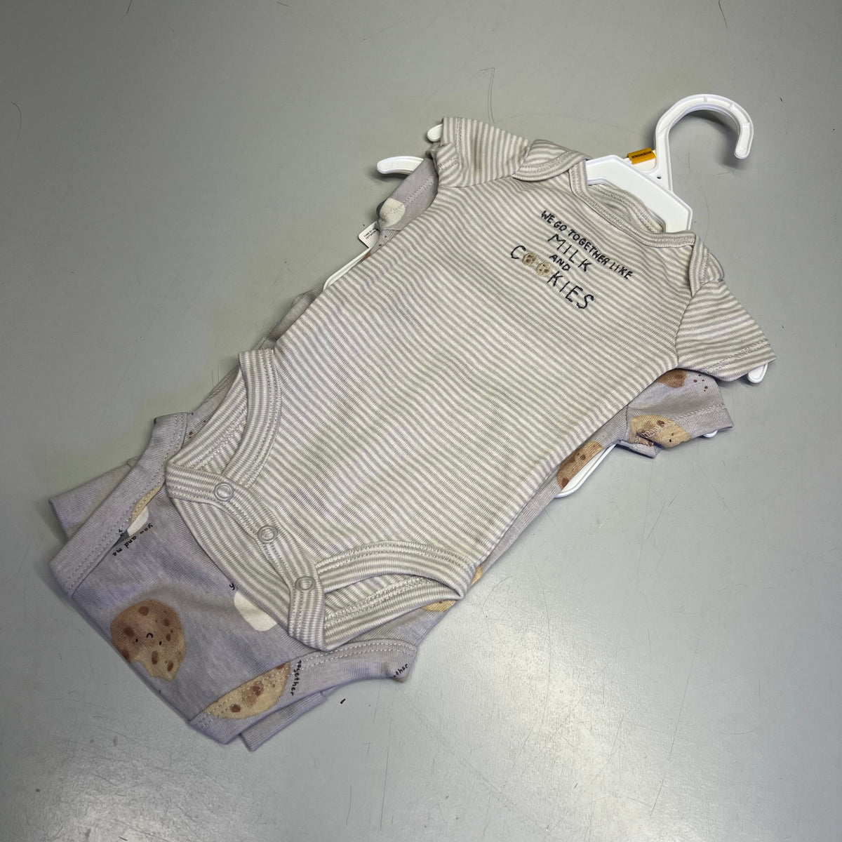 Baby cotton cookie-print and striped bodysuits set on hangers with matching pants