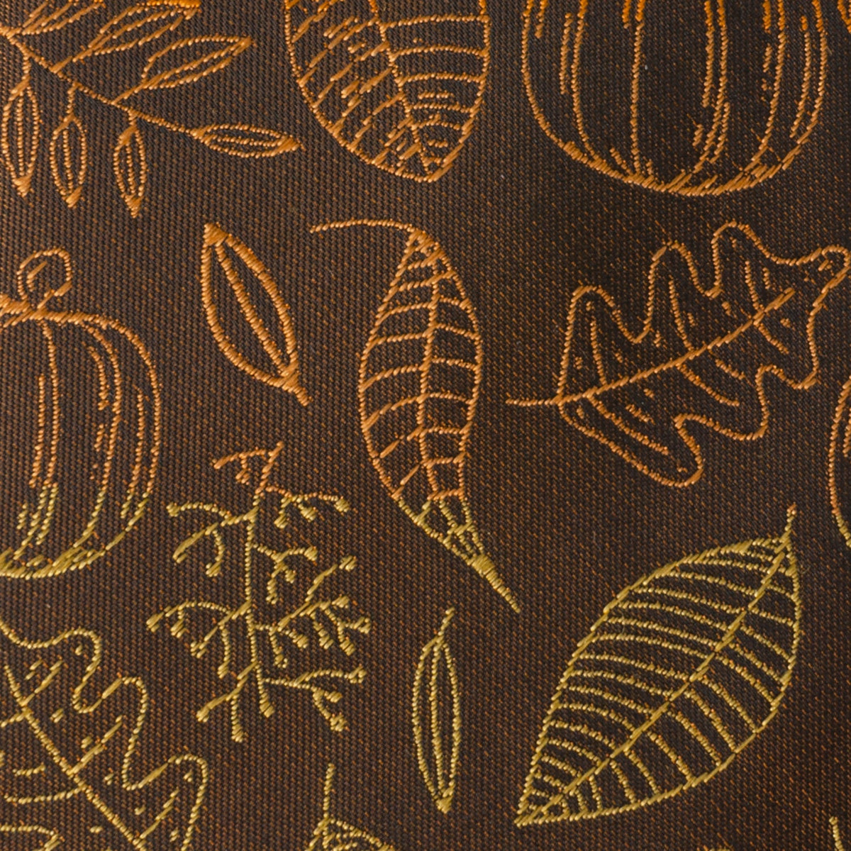 Close-up of dark brown tie fabric with gold leaf and pumpkin pattern