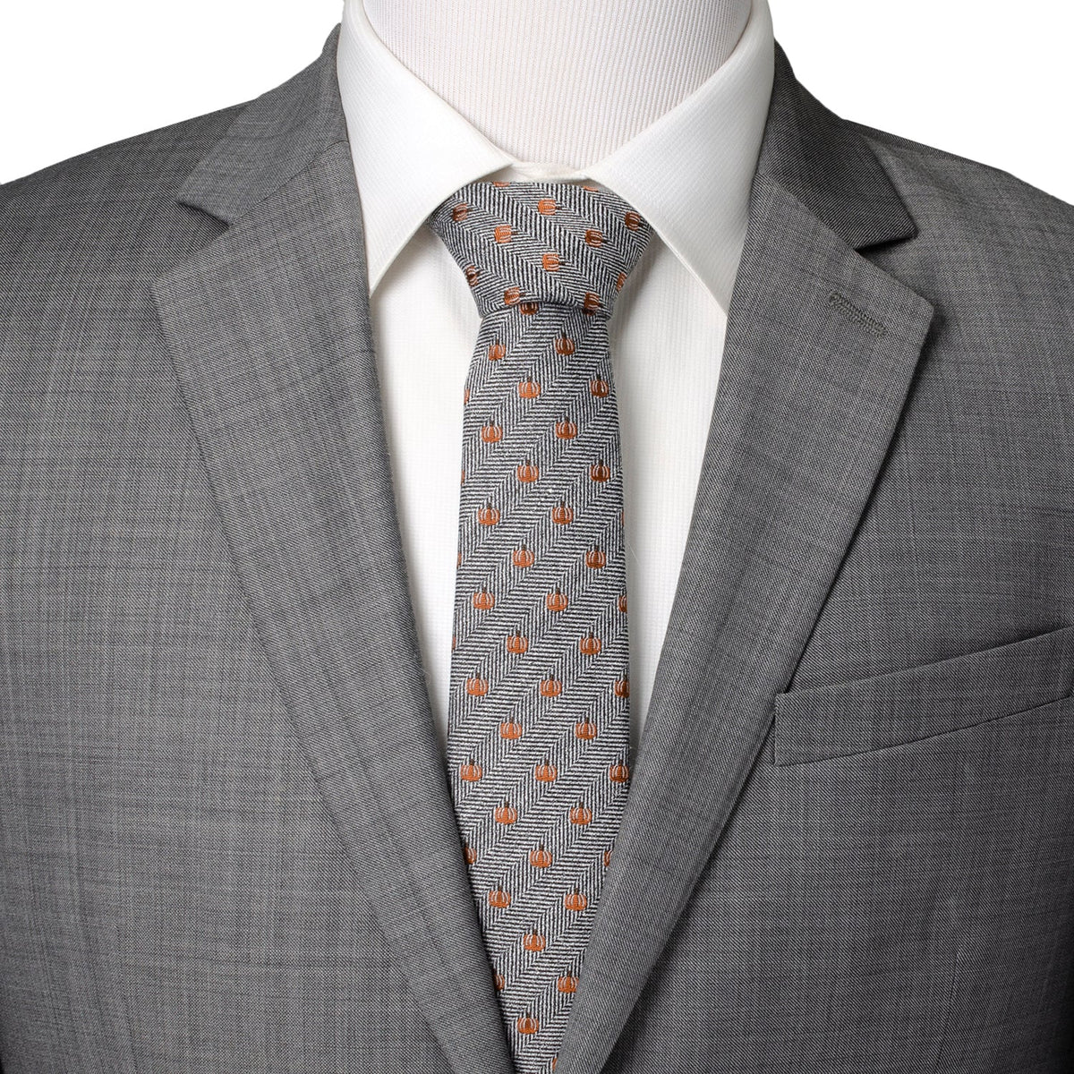 Gray suit jacket with orange pumpkin patterned herringbone necktie.