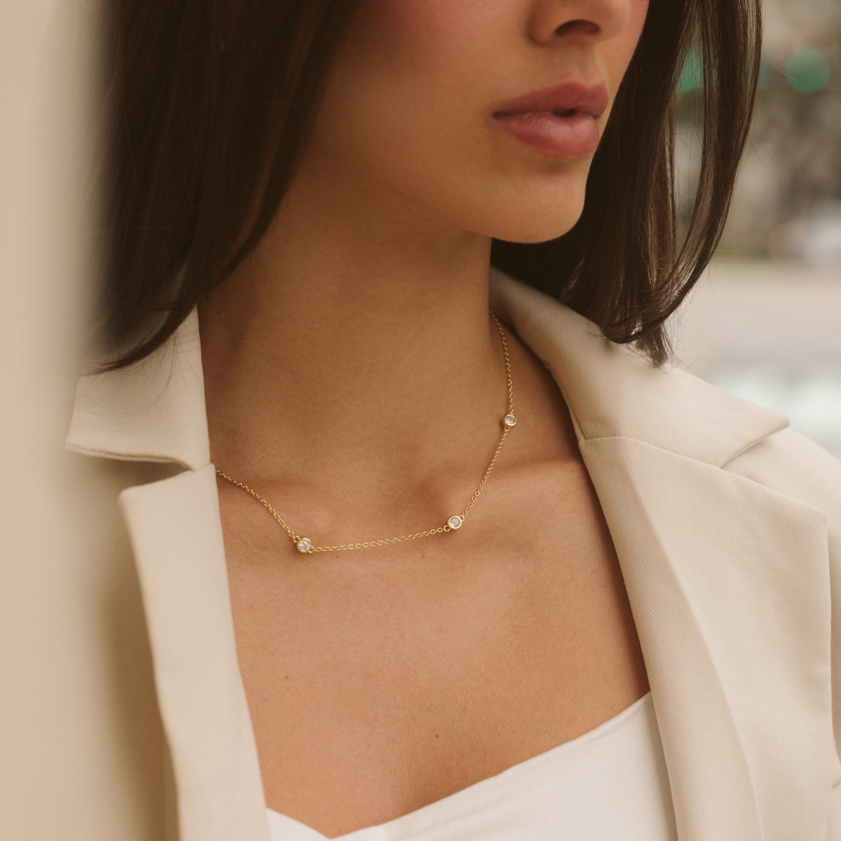 Gold filled necklace with five small round diamond-like stones on the chain