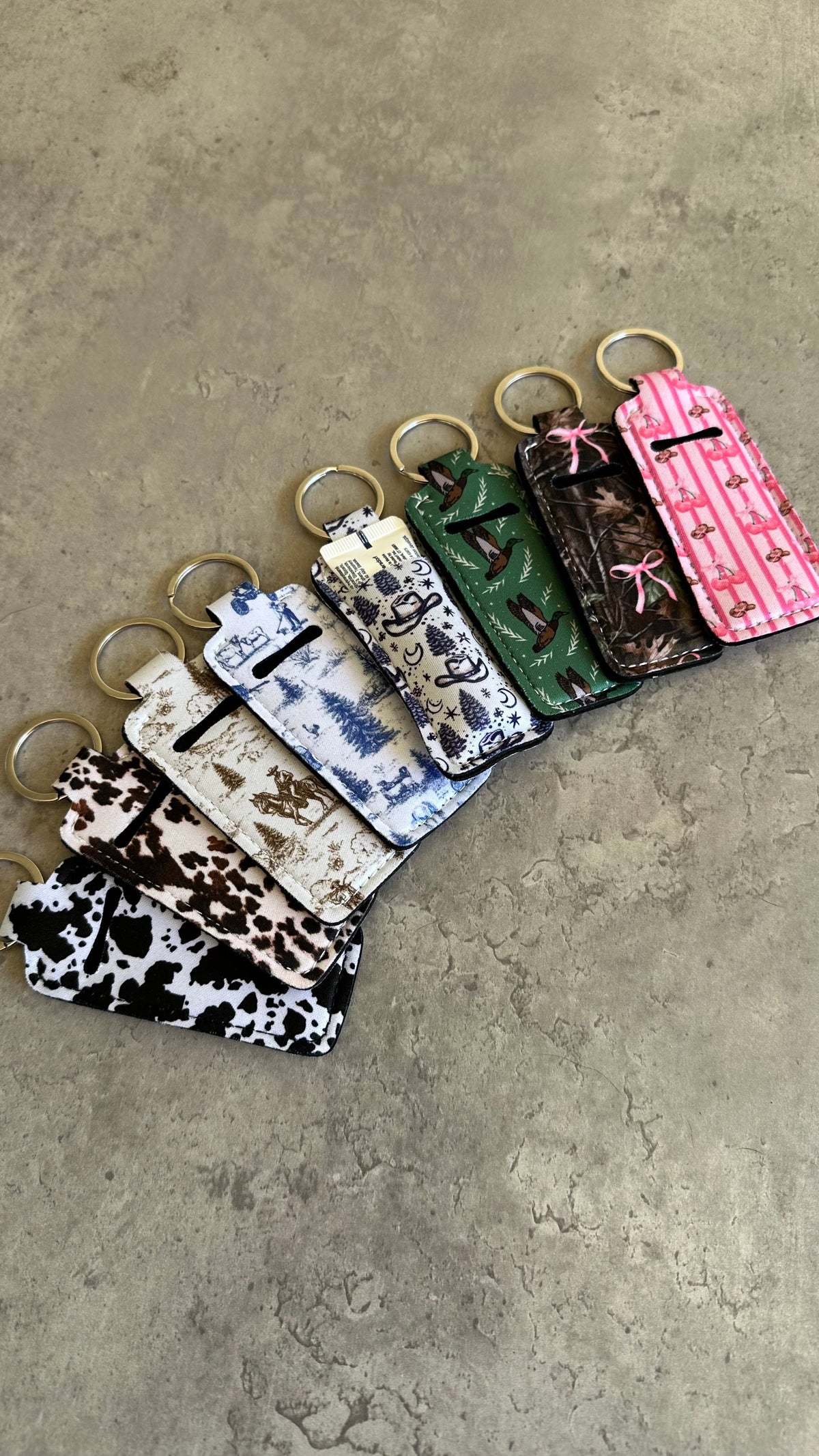 Chapstick holder keychain set with cow print, camo, and pink striped designs