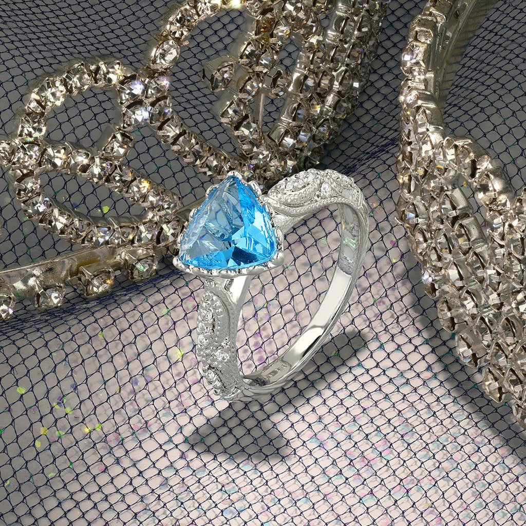 Silver-tone ring with blue teardrop center gemstone on sparkling jewelry pieces