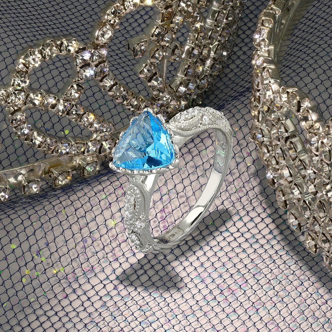 Silver-tone ring with blue teardrop center gemstone on sparkling jewelry pieces