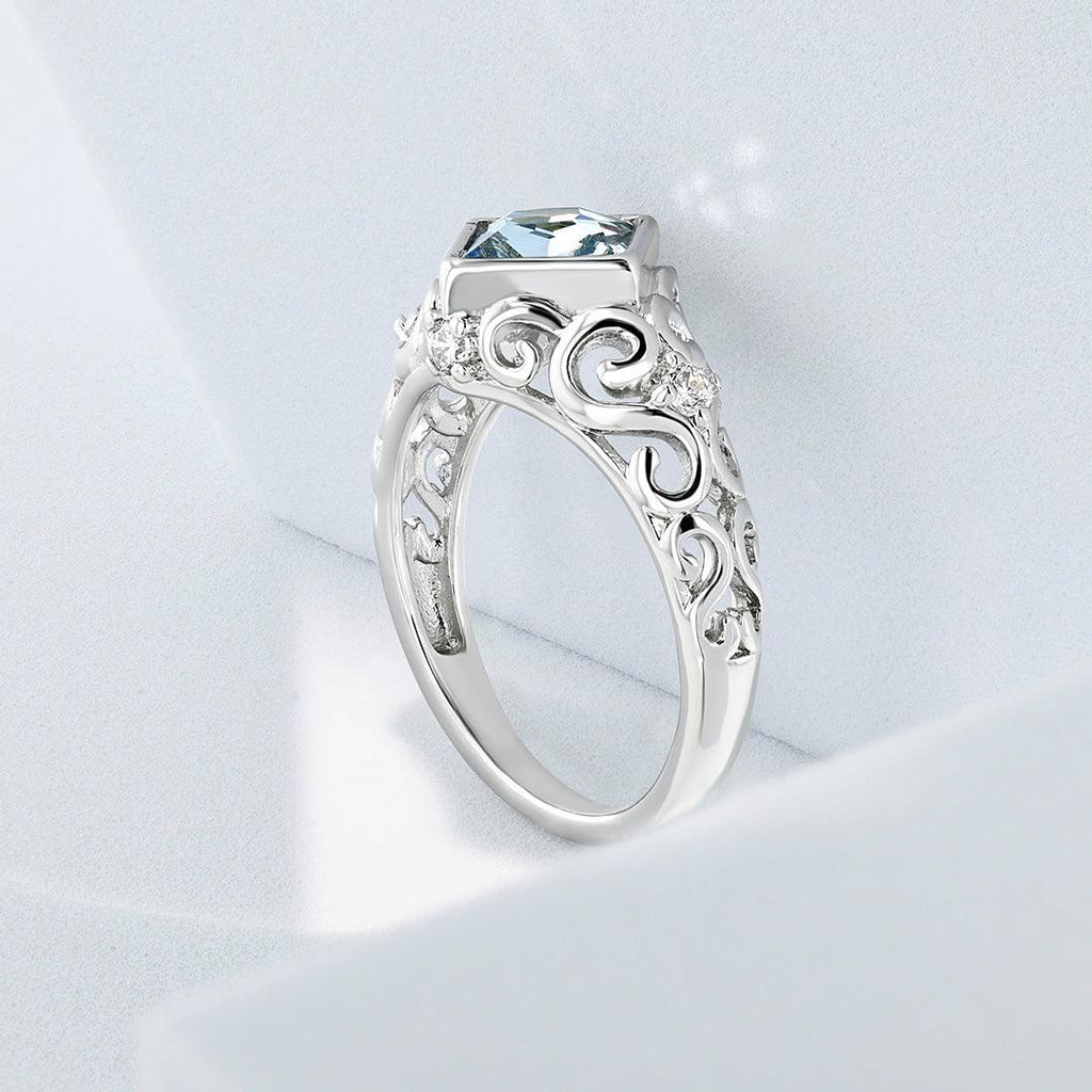 Silver-tone ornate ring with pale blue square-cut gemstone and detailed band