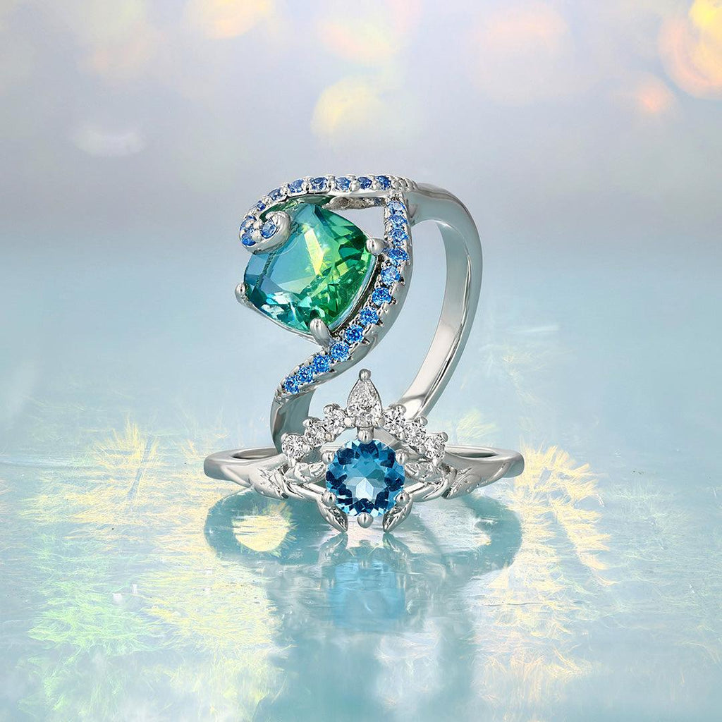 Silver-tone gemstone ring with teal oval center stone and blue side halo