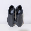Black slip-on work shoes with padded collar and smooth upper, women's pair