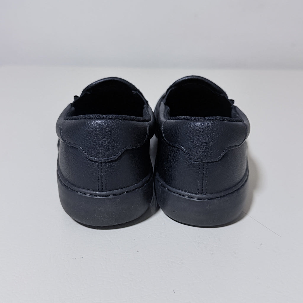 Black slip-on work shoes, rear view with heel stitching and padded collar