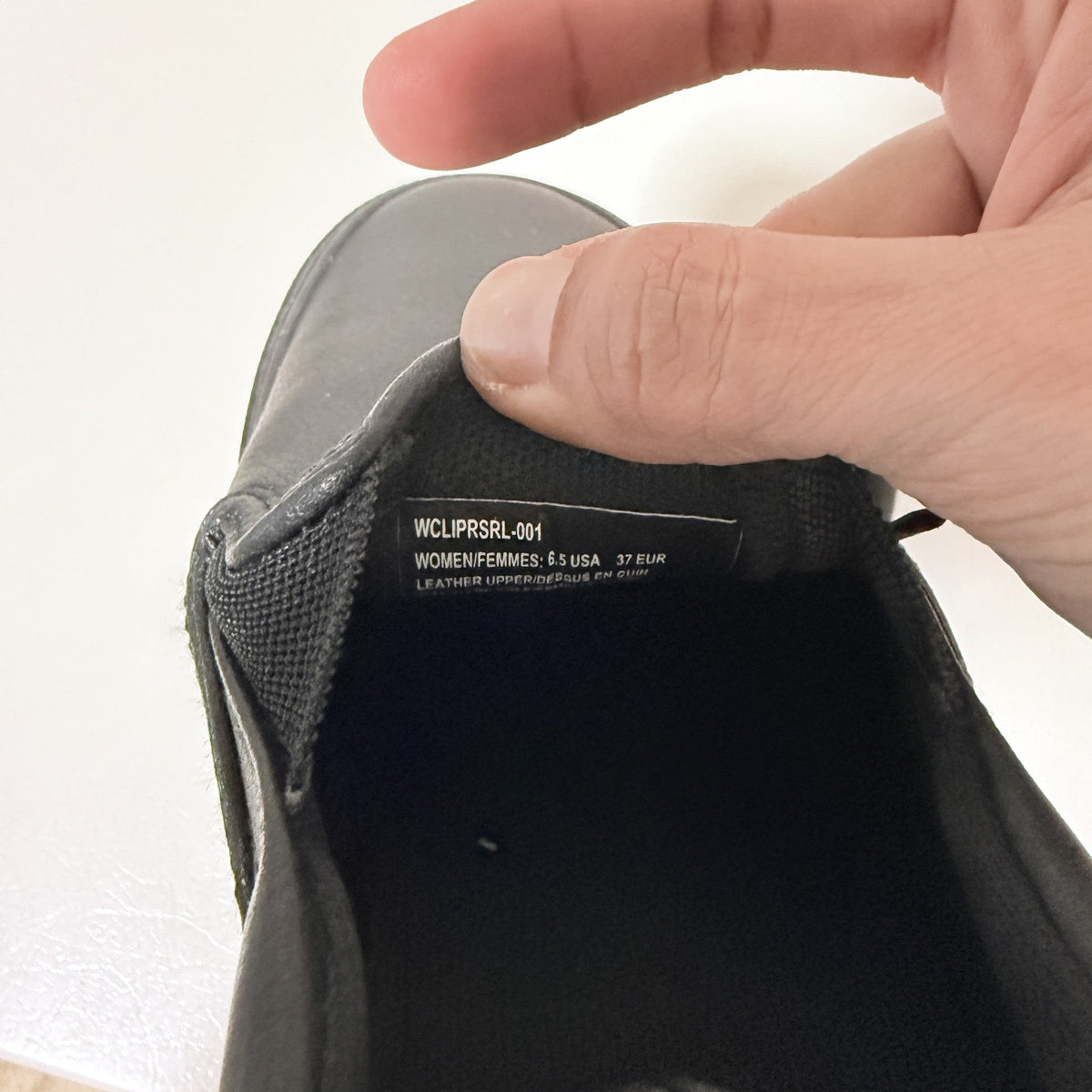 Black slip-on shoe interior tag reading WCLIPSRSL-001, women's size 6.5