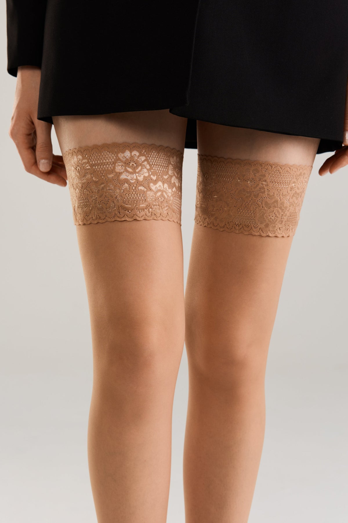 Bronze sheer stockings with floral lace upper band and silicone grip, close legs