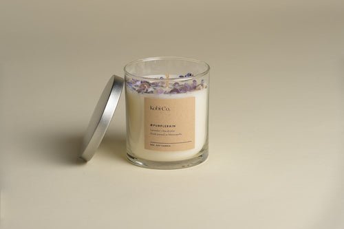Scented candle in glass jar with dried lavender garnish on top