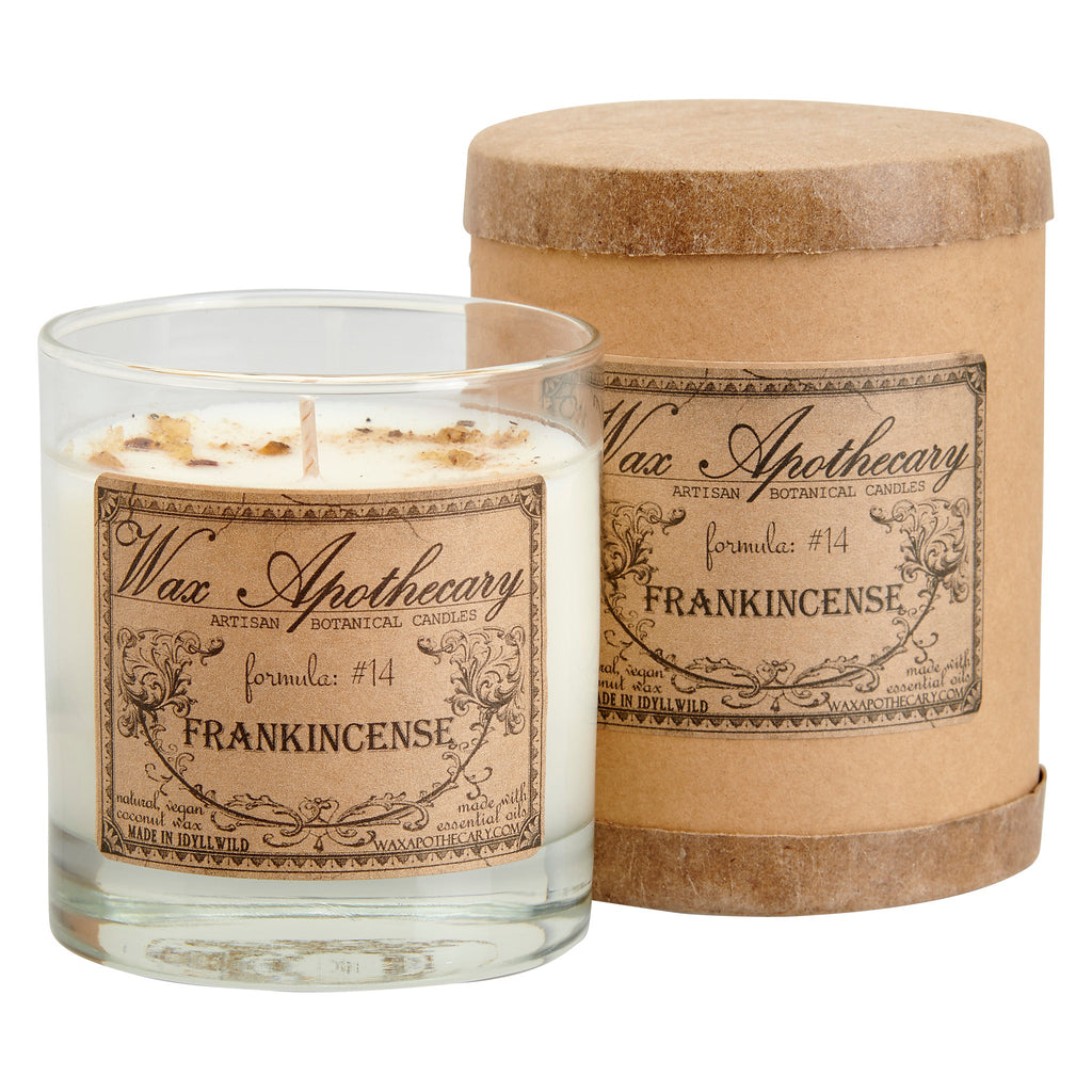 Clear scotch glass candle with Frankincense label beside matching kraft cylinder container
