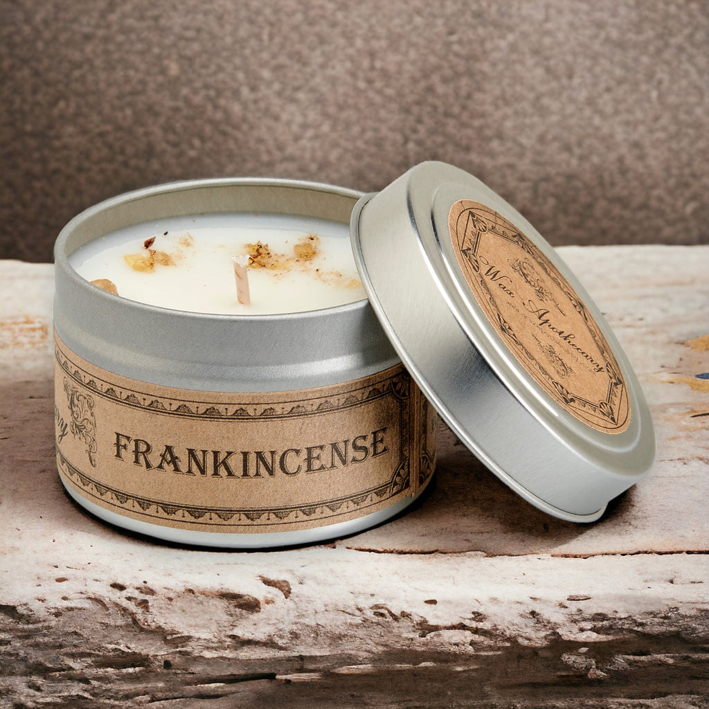 Silver travel candle tin with white candle, lid flipped open, tan label band