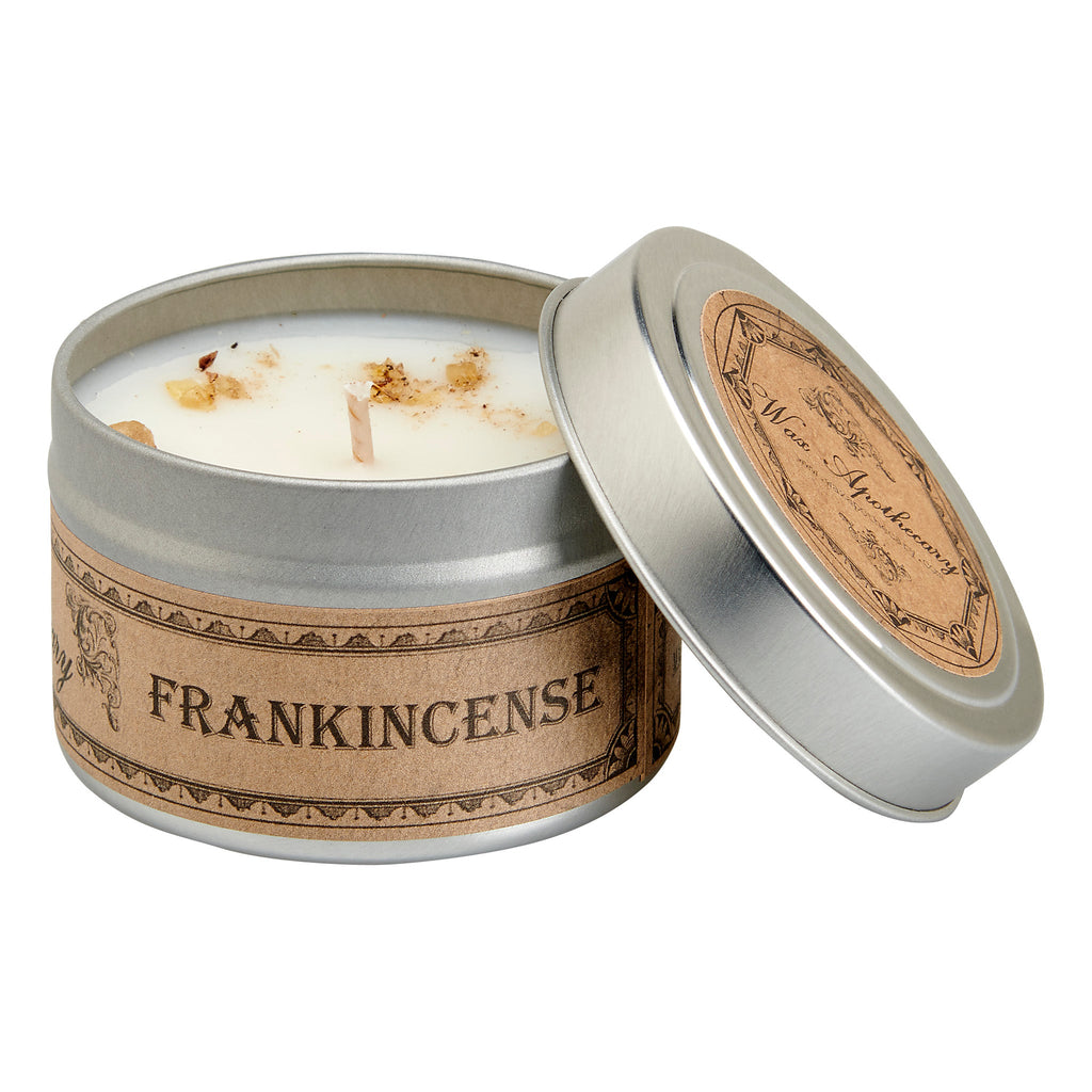 Open silver travel candle tin showing white candle inside and tan Frankincense band