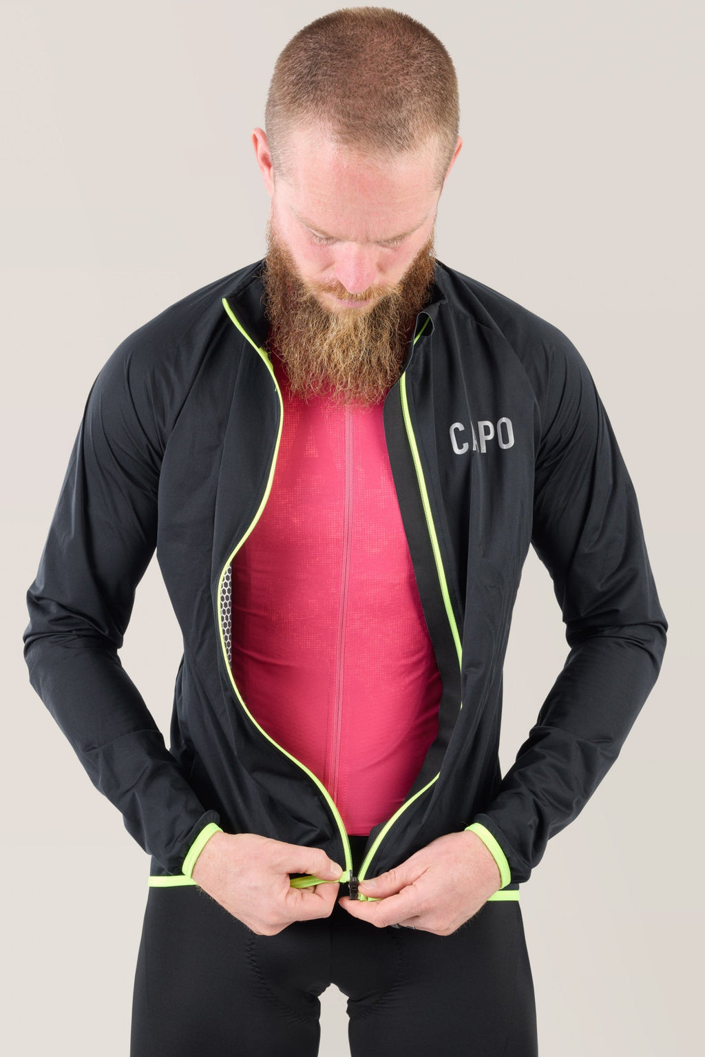 Black rain jacket with front zip open, neon lime piping around collar