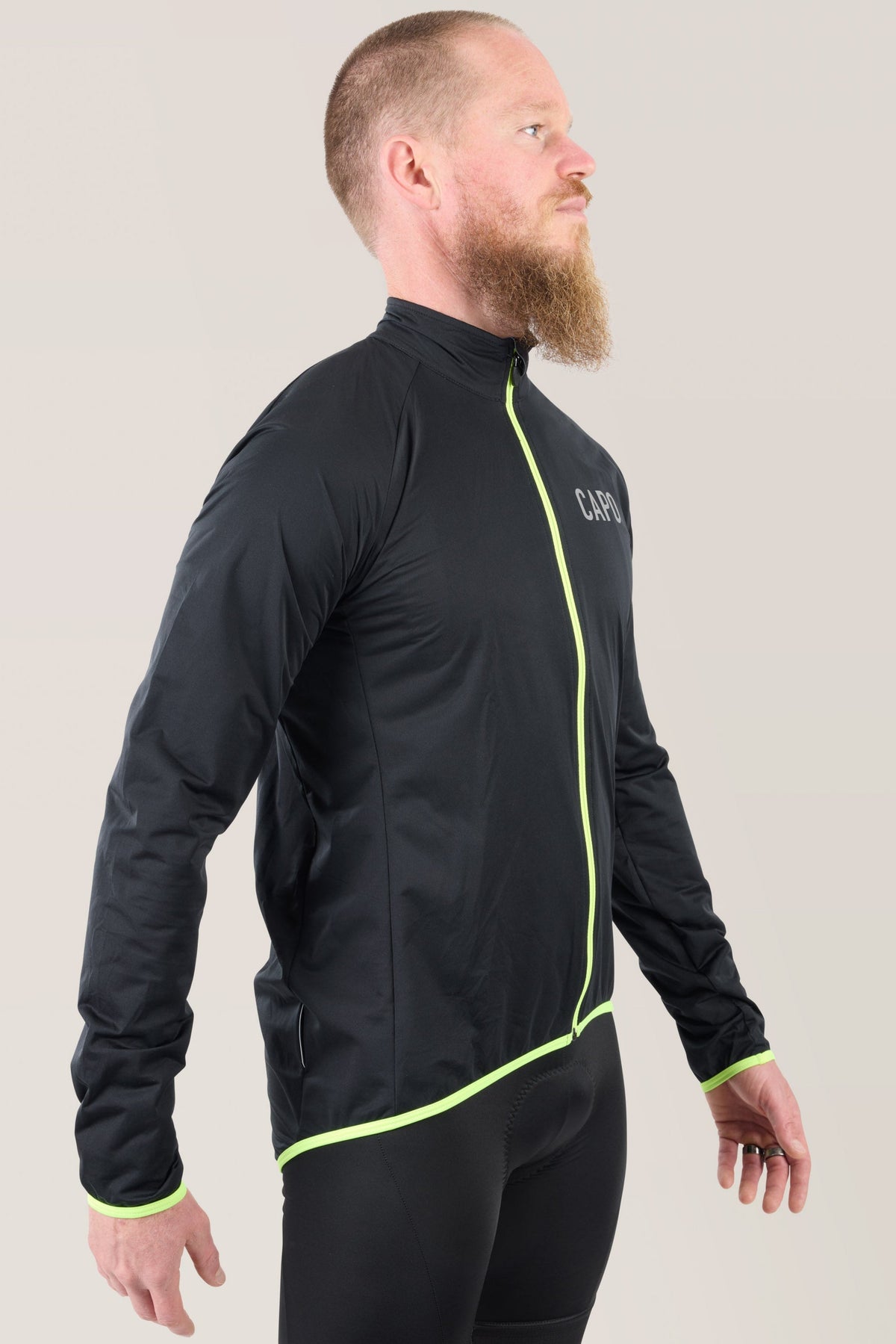 Black rain jacket with neon lime vertical seam and zipper, 3/4 side view
