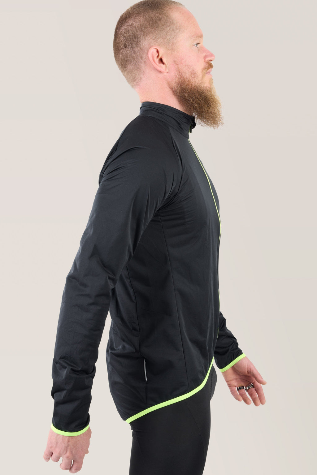 Black rain jacket with neon lime trim along sleeves and hem, side profile