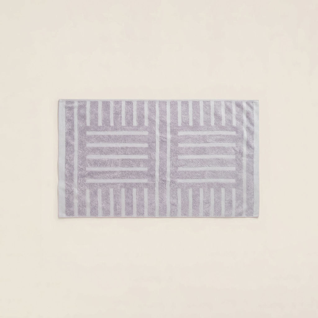 Lavender cotton bath towel with bold striped geometric border, folded flat