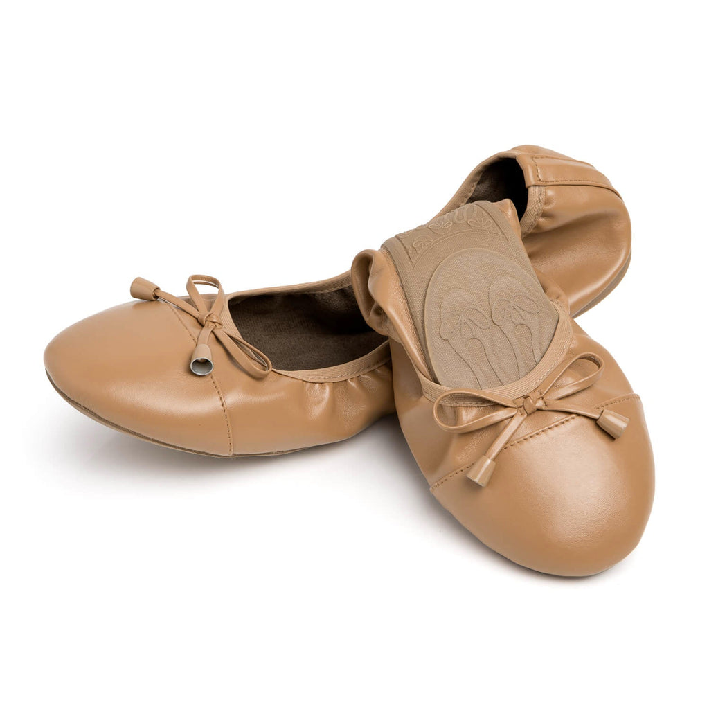 Caramel leather flats with tie bows and embossed floral medallion detail