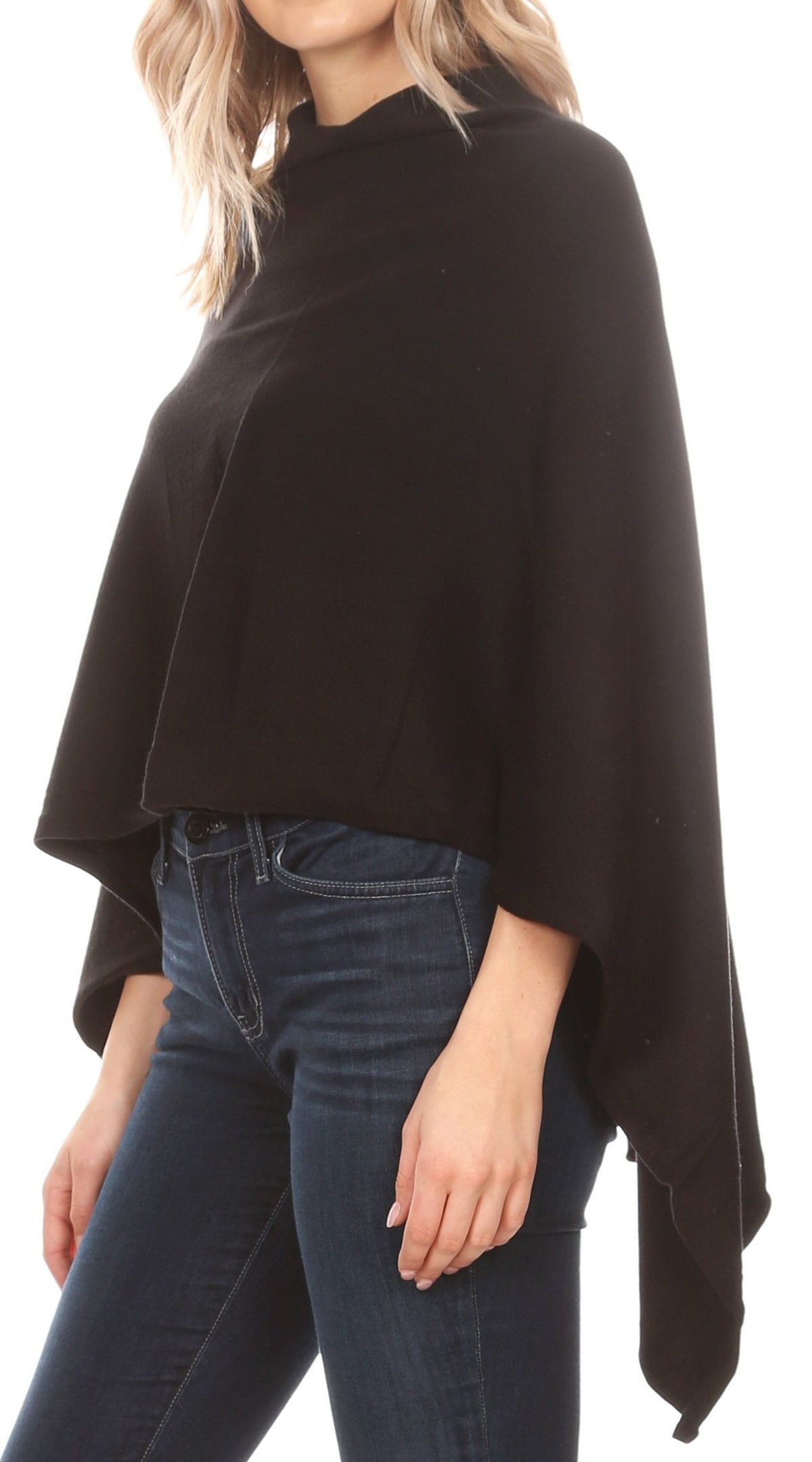Black cape poncho pullover featuring a wide drape and high collar above jeans