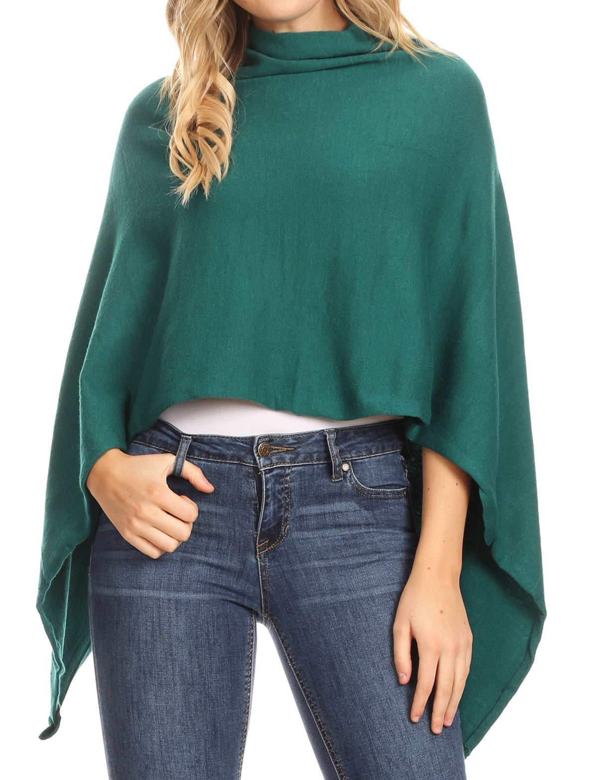 Dark green cape poncho pullover with draped sides and high neck over jeans