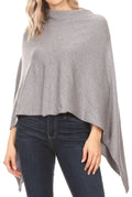 Women’s grey cape poncho with draped sleeves and high neckline over dark jeans