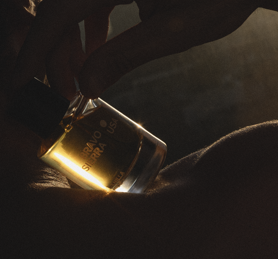 Amber perfume bottle close-up with black cap, Vanilla Hide branding
