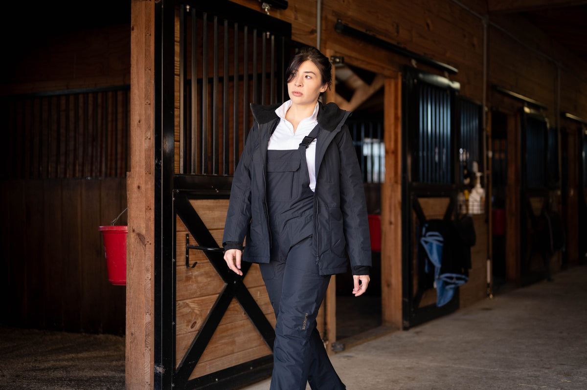 Black insulated riding jacket with hood, front zipper, and structured collar