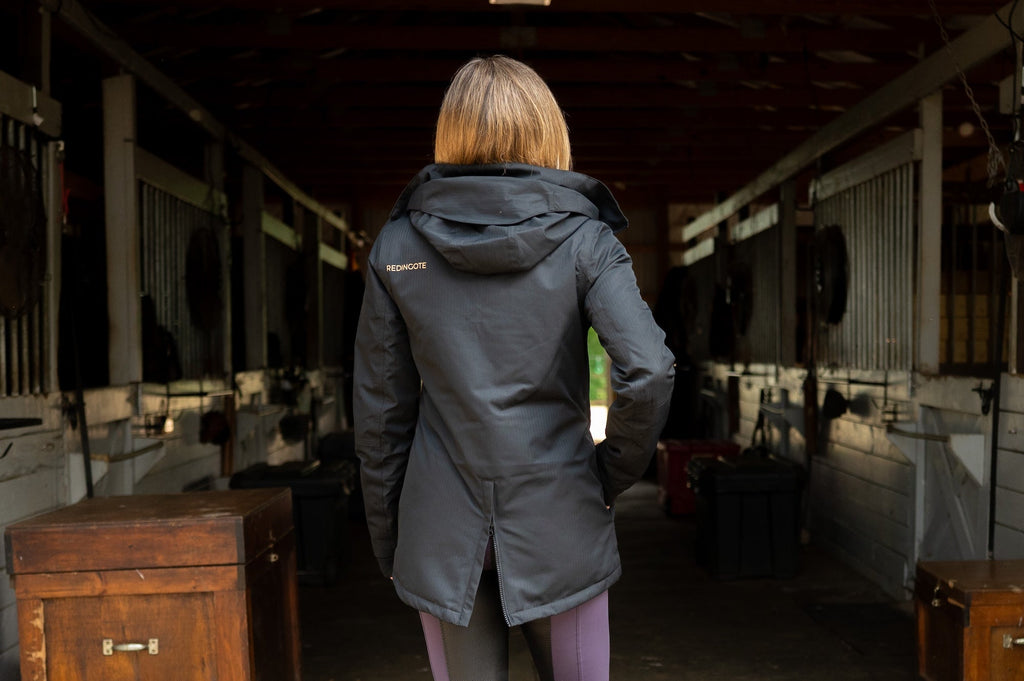 Black insulated riding jacket back view with hood and long hem