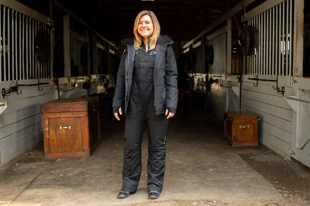 Black insulated riding jacket with hood and front zipper, full-length view