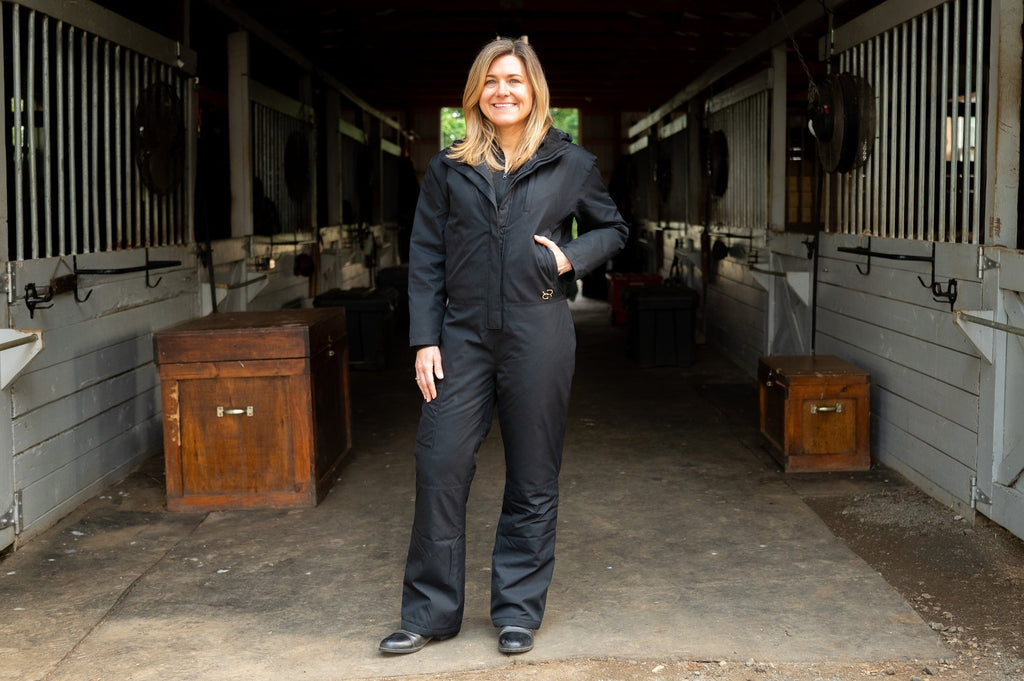 Dark insulated hooded jumpsuit with front zipper and long sleeves, full-length legs