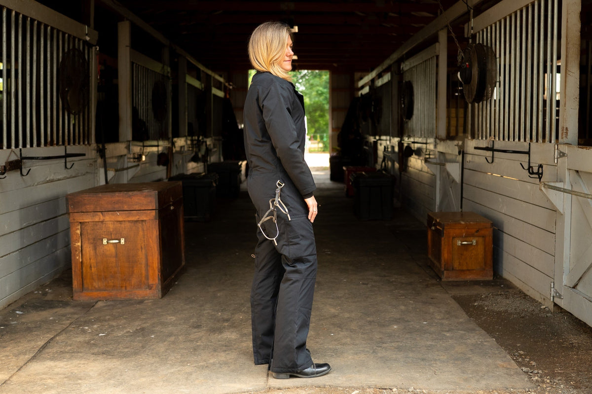 Side view of dark insulated hooded jumpsuit with front zipper and tapered pant legs