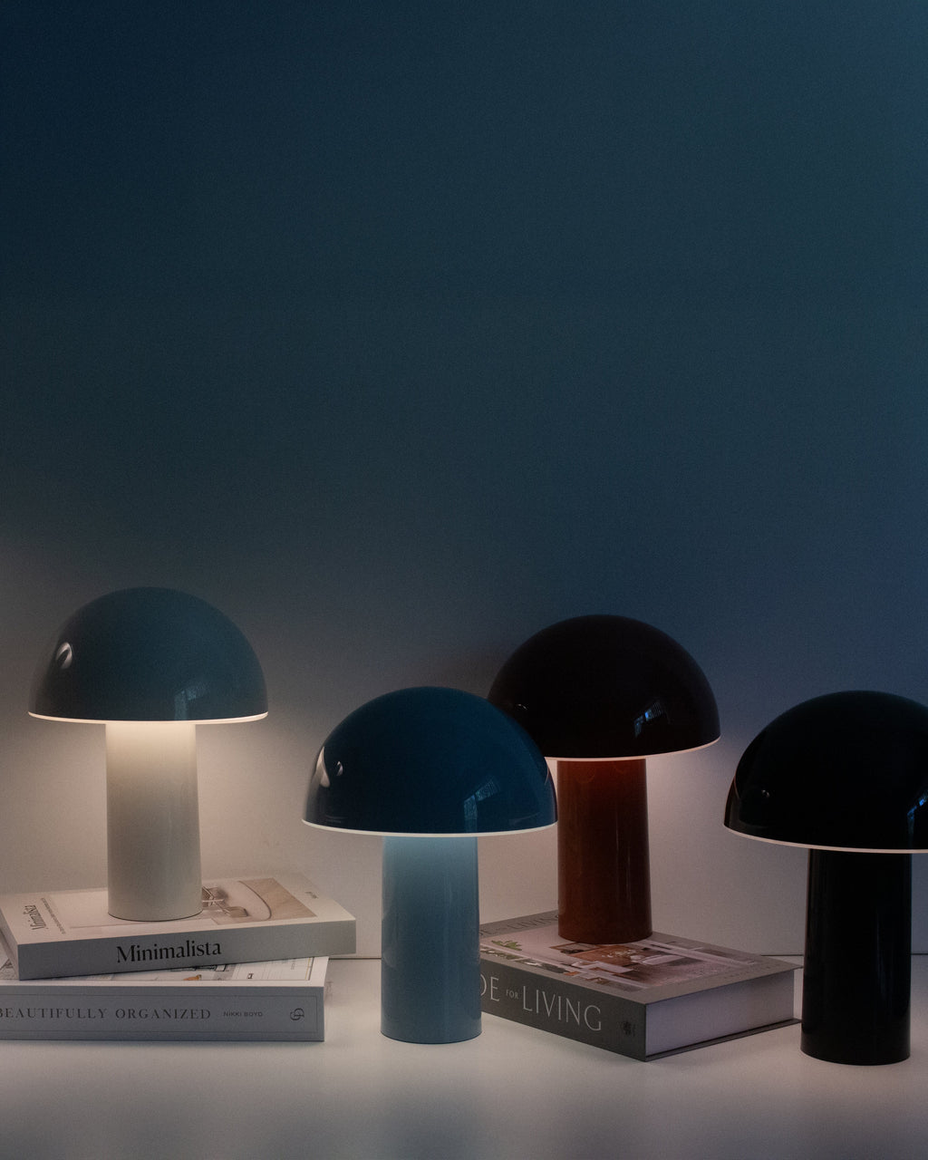 Set of colored portable lamps with domed shades and cylindrical bases, lit