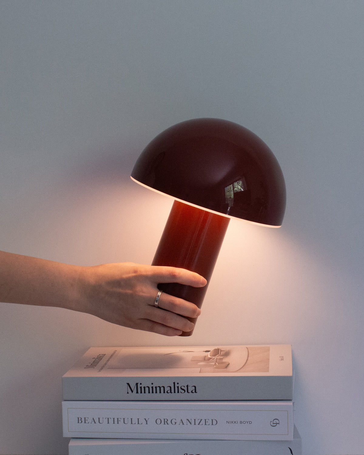 Red portable lamp with dome shade and cylindrical base, warm light glow