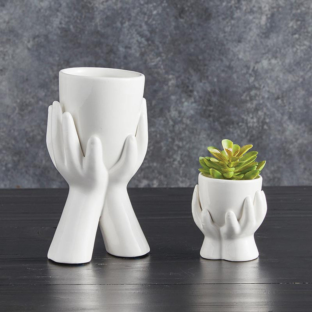 Pair of white ceramic hand planters, one smaller with succulents