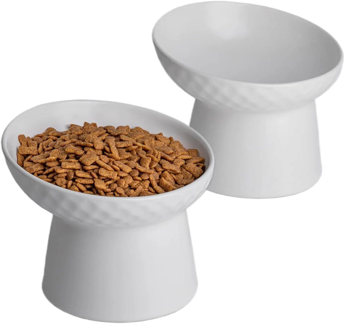 Pair of white raised tilted ceramic cat bowls, one filled with kibble