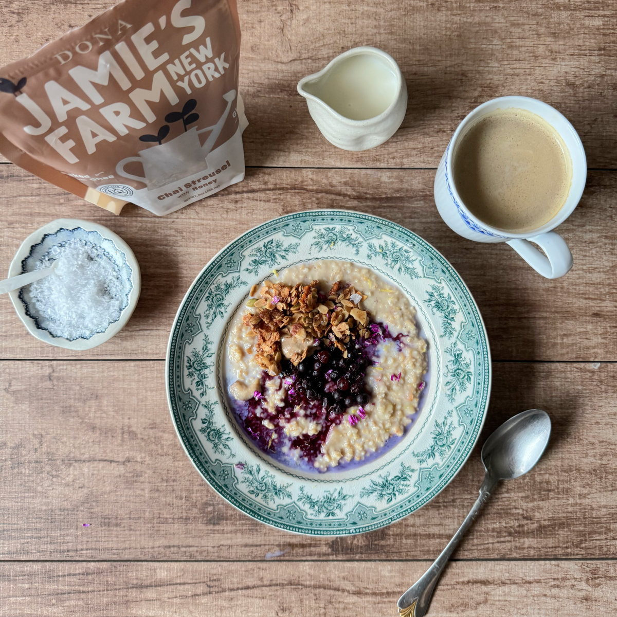 Granola bowl with blueberries and yogurt, with a granola pouch and milk cups nearby