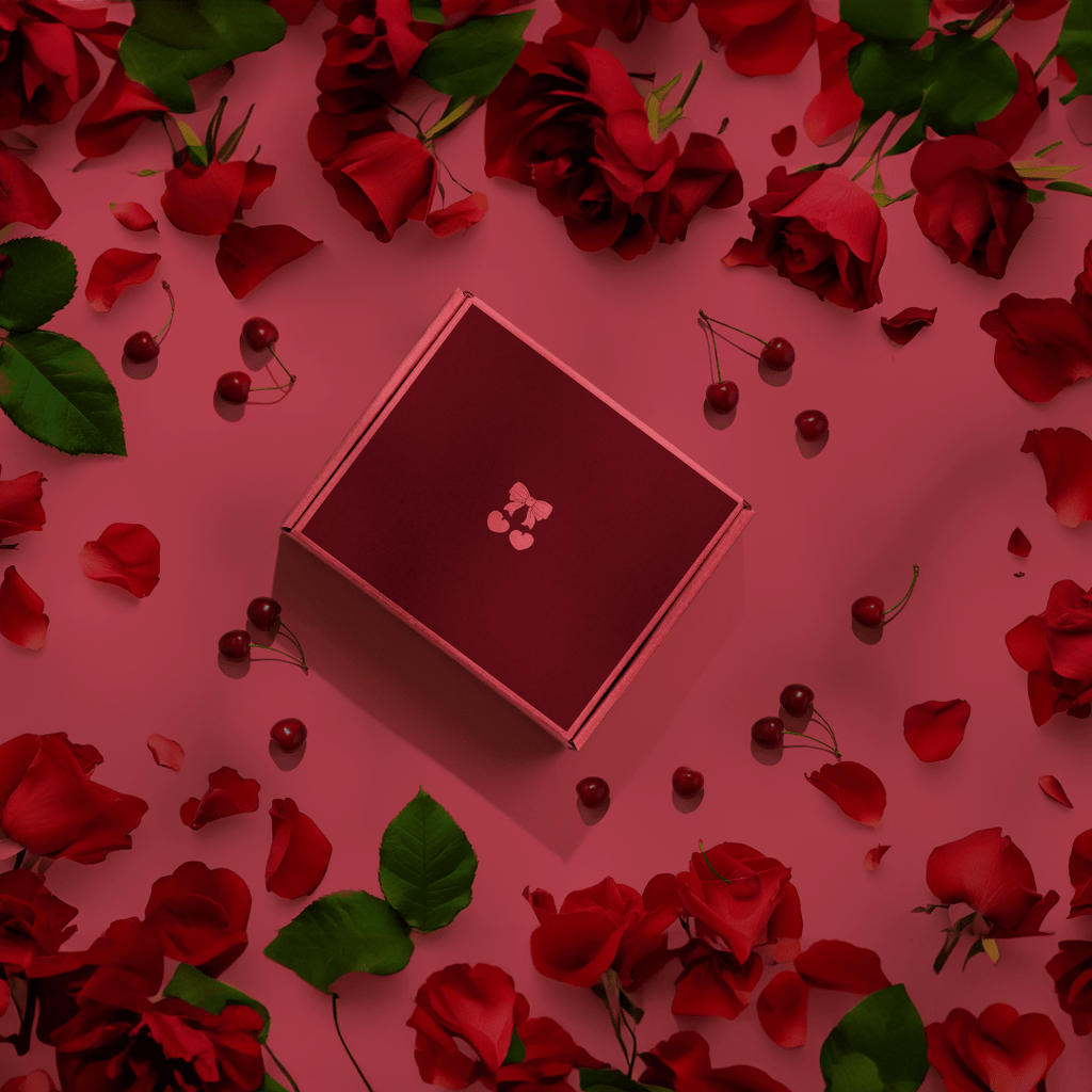 Square cherry-themed gift box with pink border on rose petals