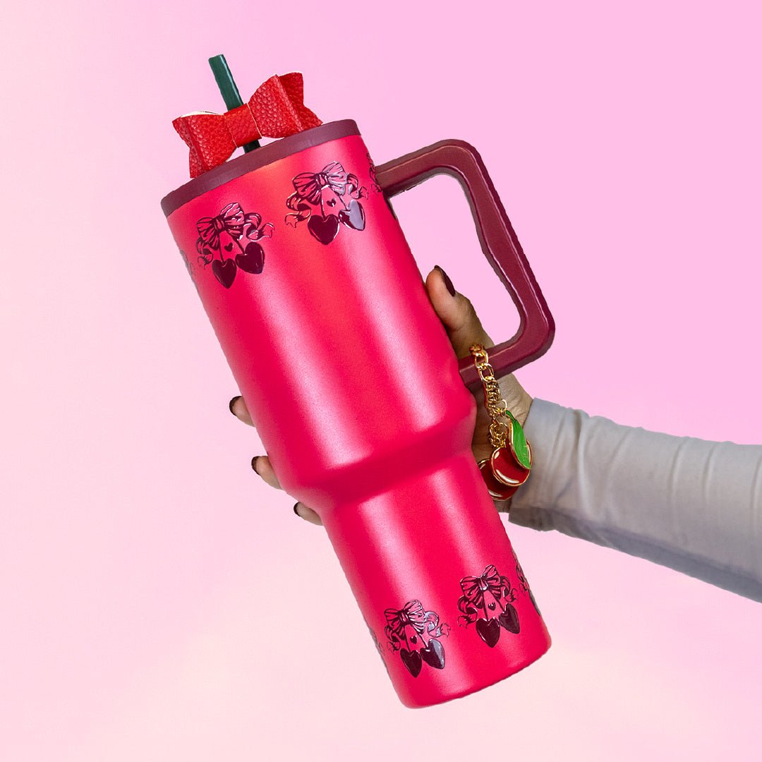 Red cherry tumbler with handle, topped with red bow and ribbon