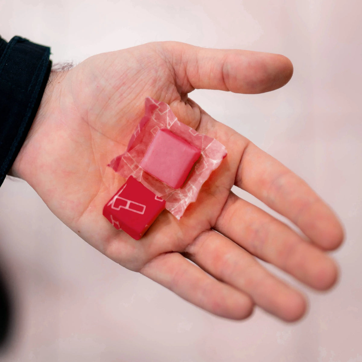 Red energy chew cubes in hand with foil wrappers
