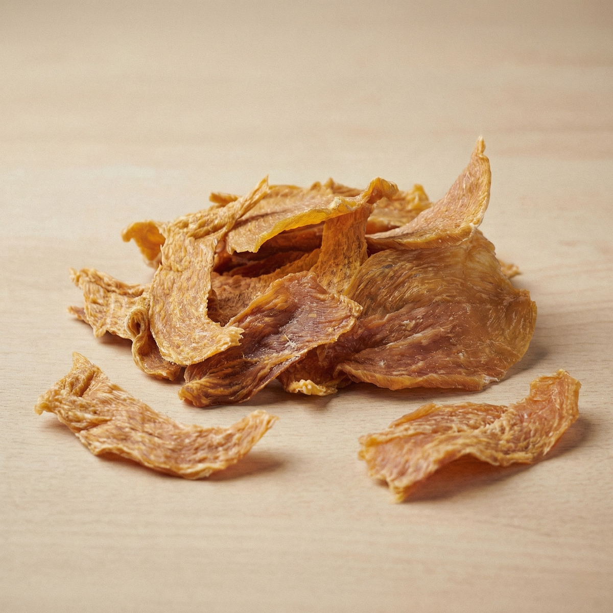 Dried chicken breast strips scattered on a surface