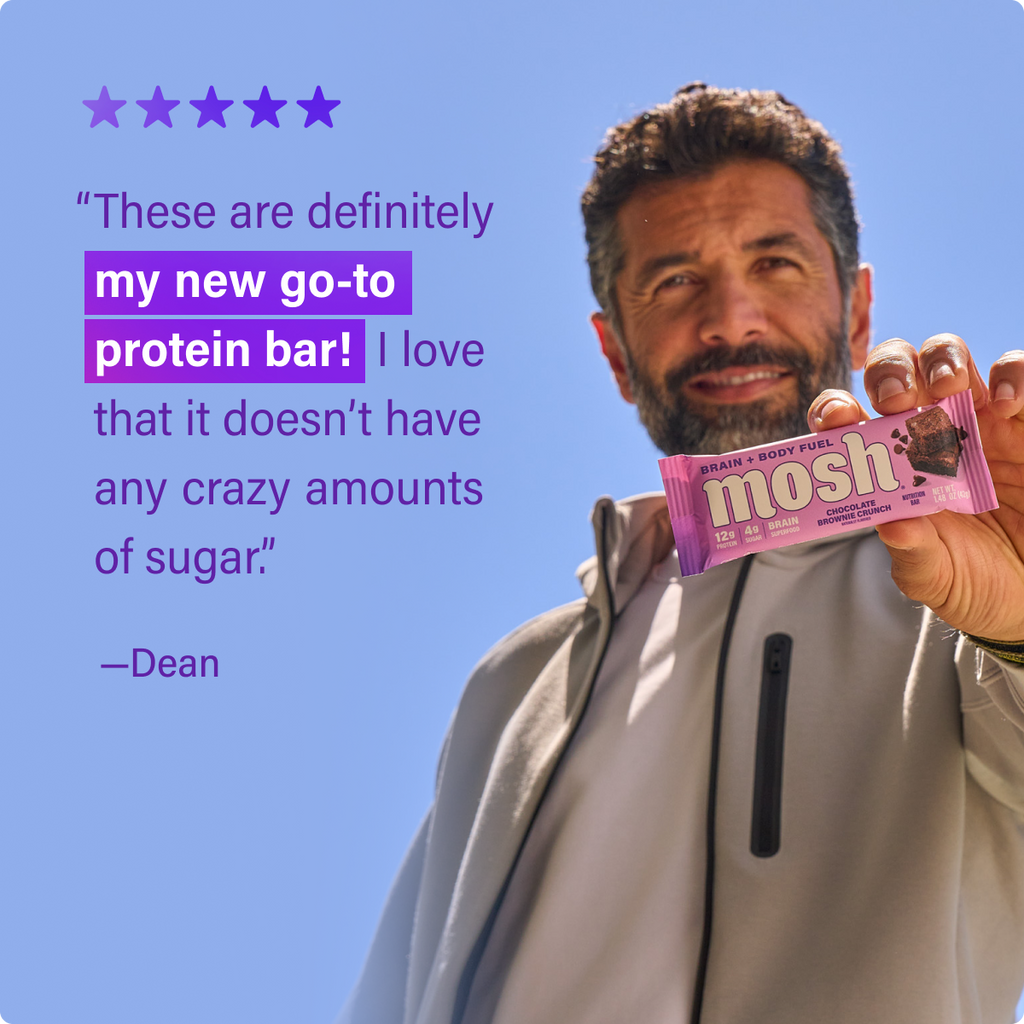 Chocolate brownie crunch protein bar held in hand, showing purple wrapper