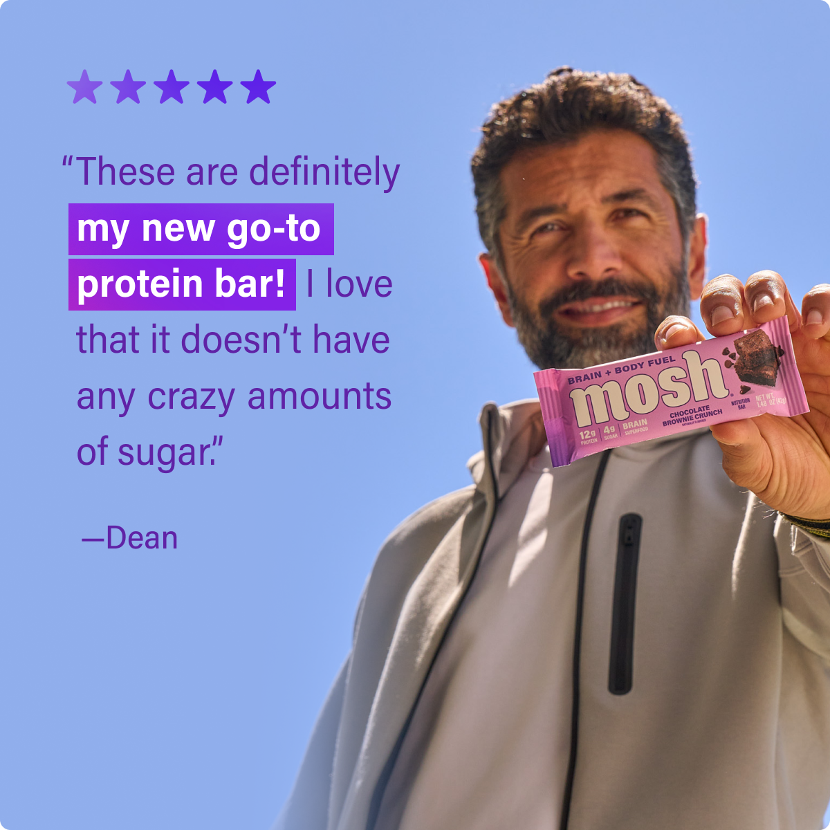 Chocolate brownie crunch protein bar held in hand, showing purple wrapper