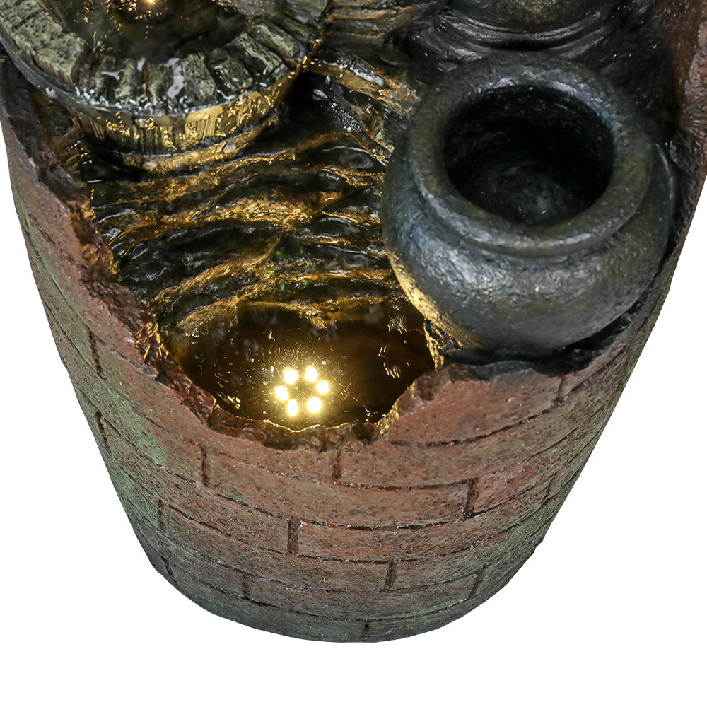 Top-view of barrel fountain showing water pool, gold highlights, and circular outlet spout