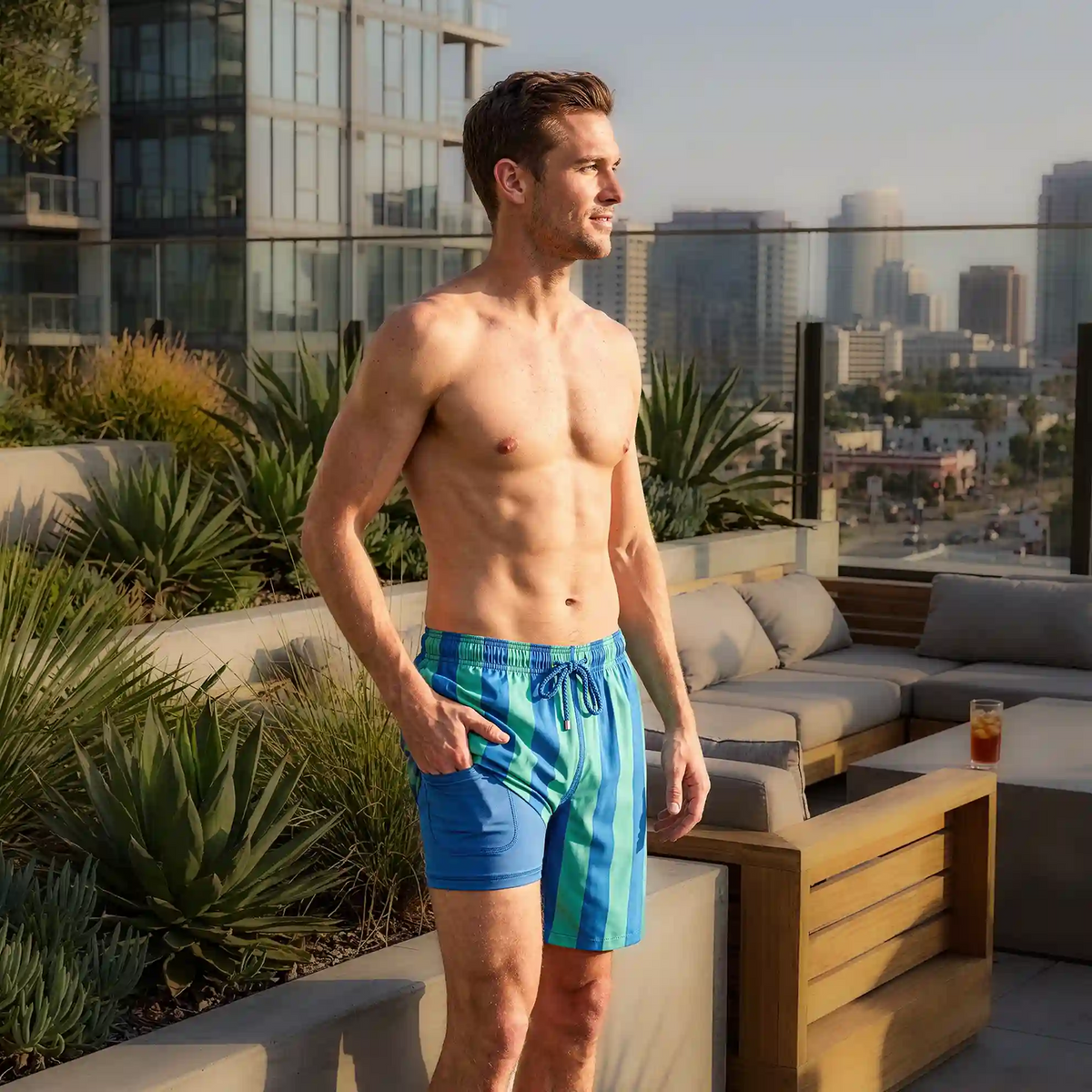 Blue and green striped swim trunks with elastic waistband and drawstring