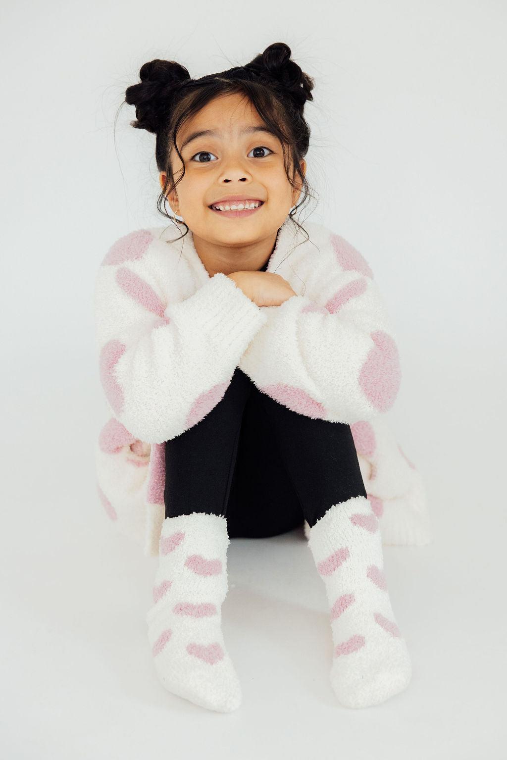 Light pink heart cozy cardigan, fuzzy white knit with light pink heart print and long sleeves.