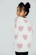 Light pink heart cozy cardigan with fuzzy white knit and long sleeves, open front.