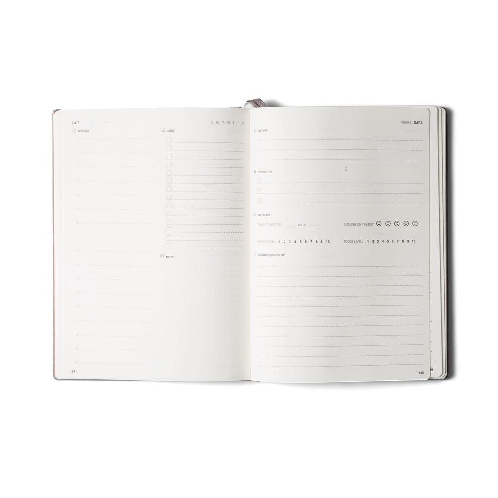 Open gray habit system planner showing lined pages and check box sections