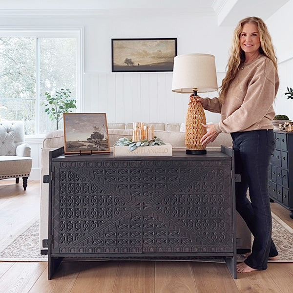 Dark wood console table with geometric carved doors and open shelf space