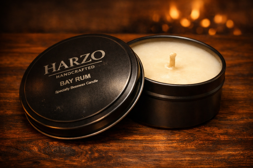 Black candle tin with lit wick beside open lid showing bay rum label