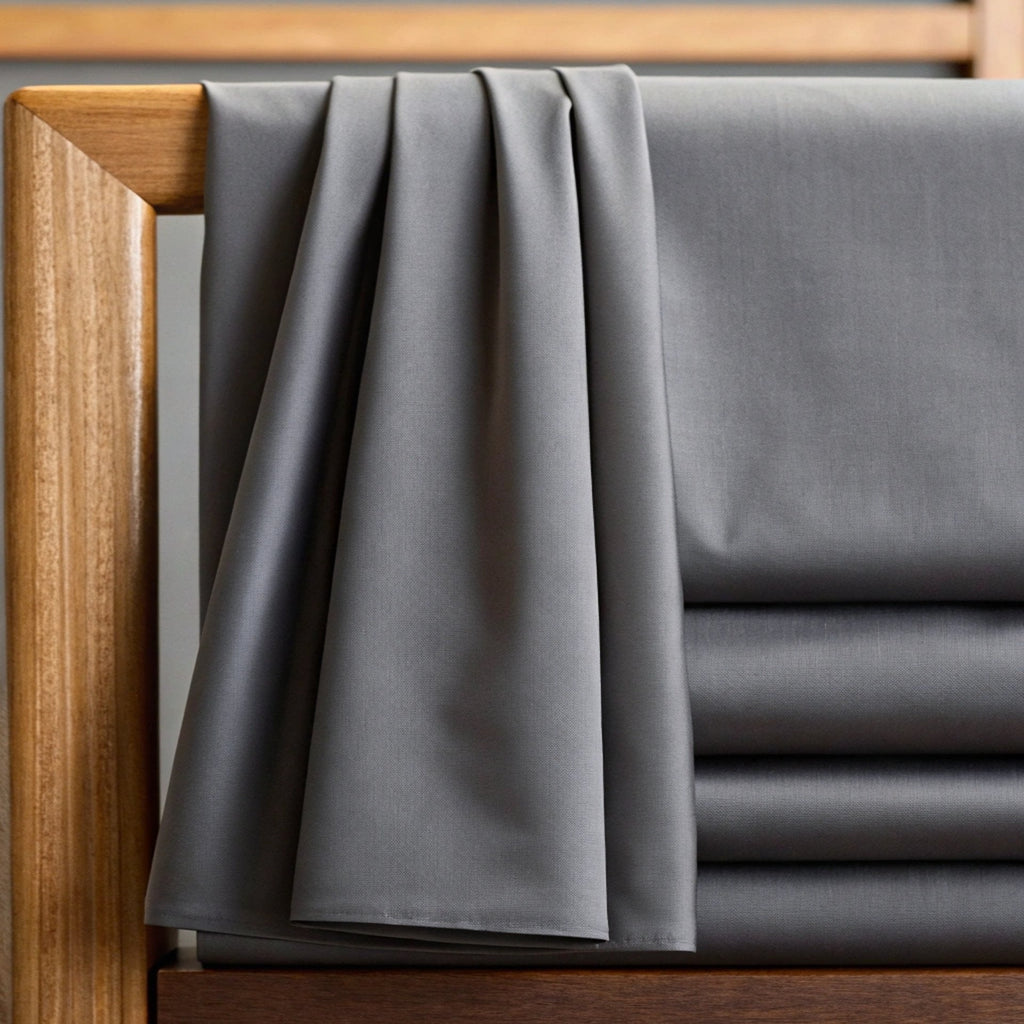 Gray bamboo sheet set with fitted and flat sheets, neatly draped at the bed edge.